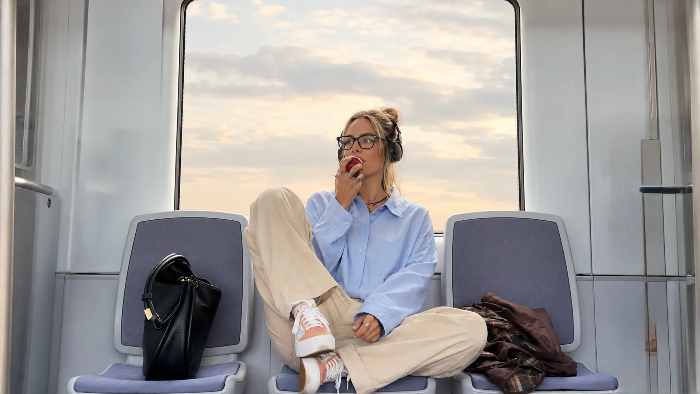 A traveler on a commuter train at sunset