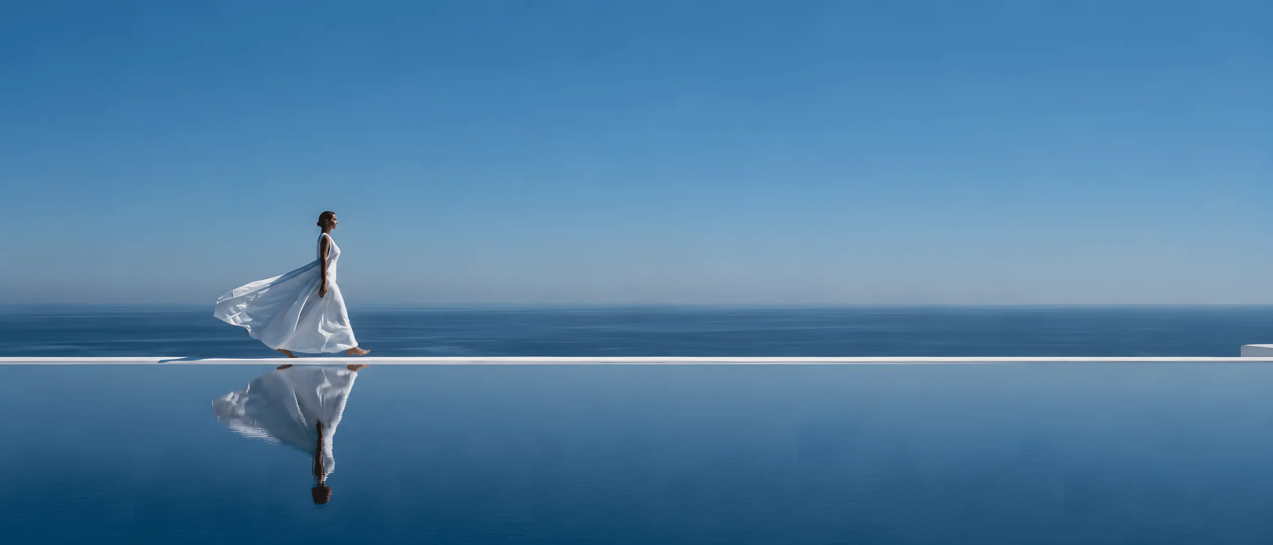 A figure walking along a mirror-still edge between sea and sky